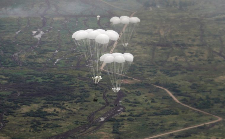 FILE PHOTO: A view from a transport military plane shows Russian airborne combat vehicles descending beneath parachutes during the exercises 