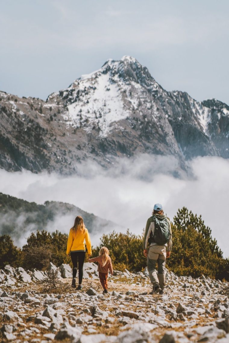 Family hiking in mountains parents with child travel outdoor active healthy lifestyle summer vacations eco tourism in Albania mother and father with kid trekking