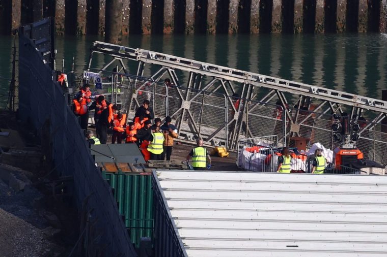 Migrants picked up at sea attempting to cross the English Channel from France disembark a Border Force vessel arriving at the Marina in Dover, south-east England, on September 19, 2025. The first migrant was returned to France on September 18 under the new deal allowing the UK to detain and deport irregular migrants deemed ineligible for asylum. In return, the UK will accept an equal number of migrants from France who can apply for a UK visa via an online platform under the pilot scheme which came into effect August and will run until June 2026. UK media reported that
