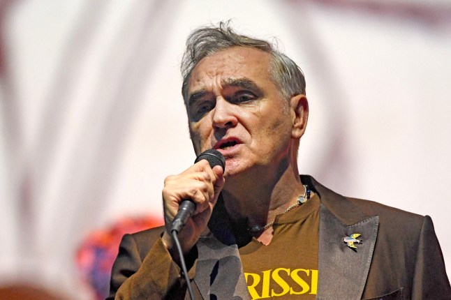 Morrissey singing into a microphone at a concert.