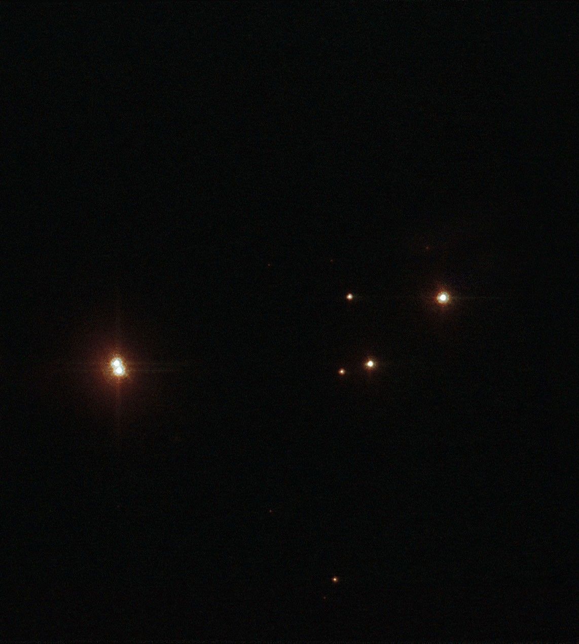 A dark background with several bright points of light resembling stars or celestial objects, much like those captured by JWST and Hubble in clusters such as Pismis 24.