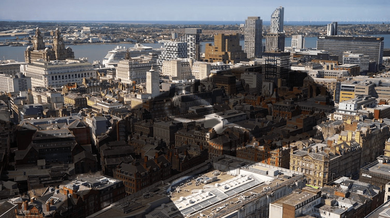 A shadow of Keir Starmer superimposed over an aerial shot of Liverpool