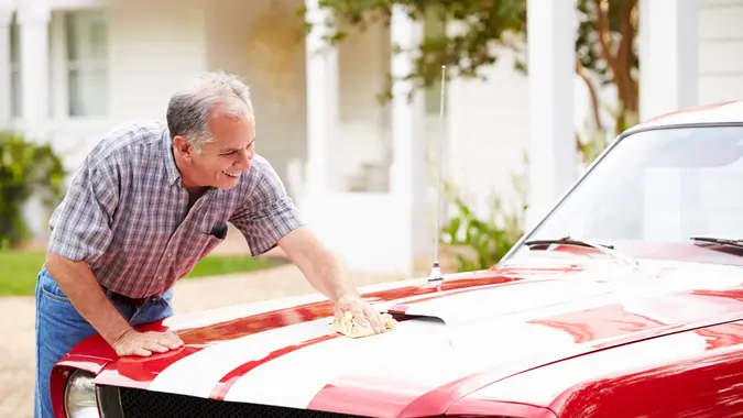 Retired man polishing vintage car