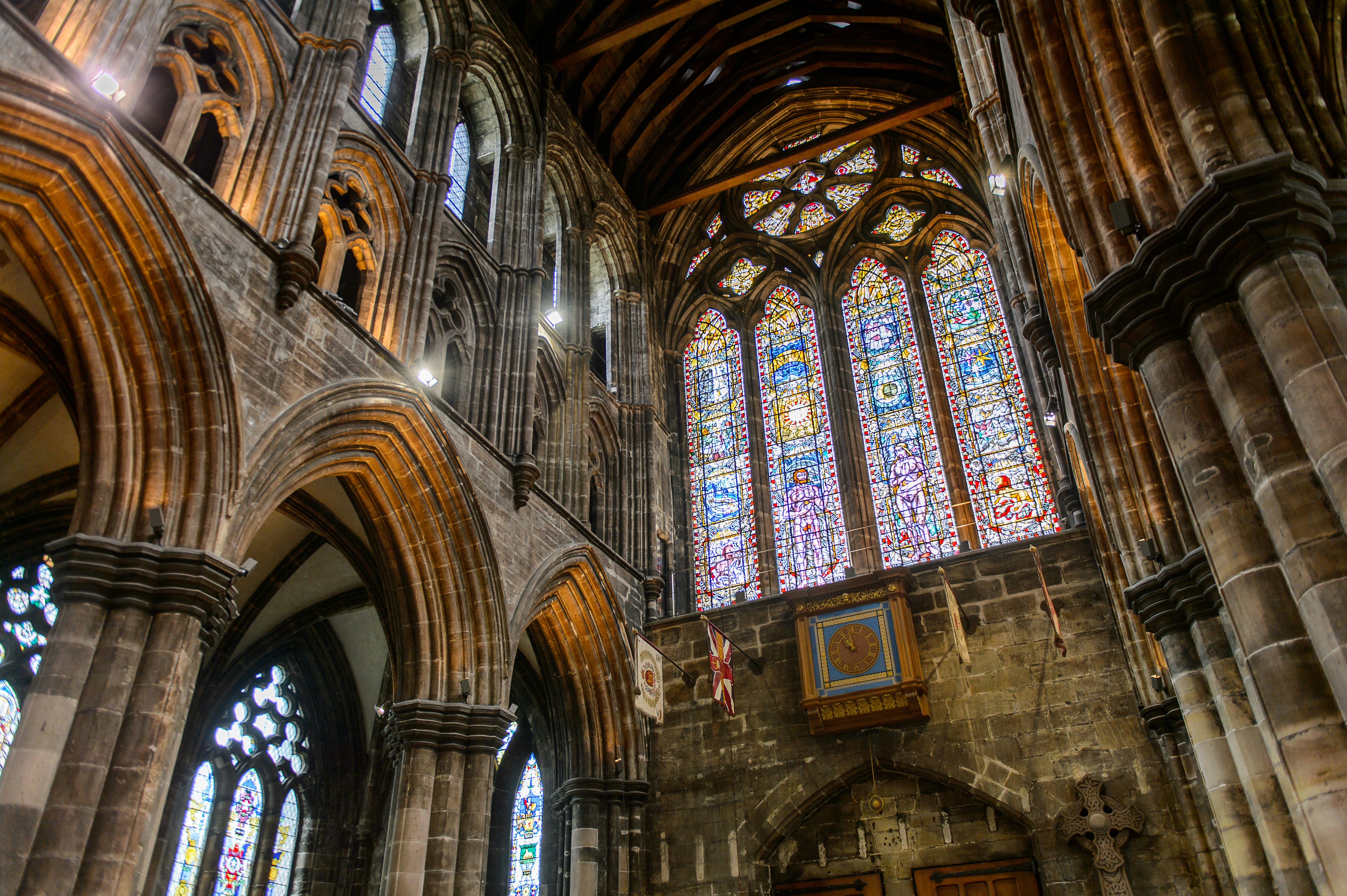 The stained glass and stone interior of the Glasgow Cathedral in Scotland.
