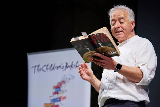 Frank Cottrell-Boyce reading from a book onstage