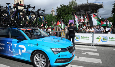 Pro-Palestinian protesters wave flags as Team Israel Premier Tech's team car drives past in Vegadeo at the start of the 15th stage of the Vuelta a Espana cycling tour, a 167 km race between A Veiga/Vegadeo and Monforte de Lemos, on September 7, 2025. (Photo by Miguel RIOPA / AFP)