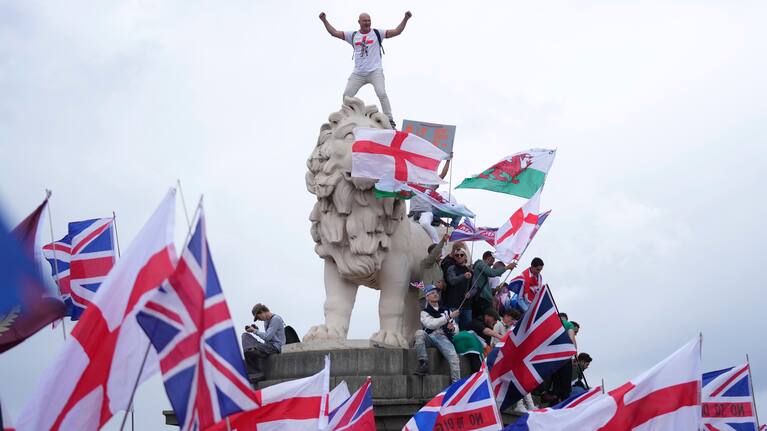 A demonstrator stands on the head of the South Bank lion that sits on the side of the Westminster Bridge, during a Tommy Robinson-led Unite the Kingdom march and rally in London