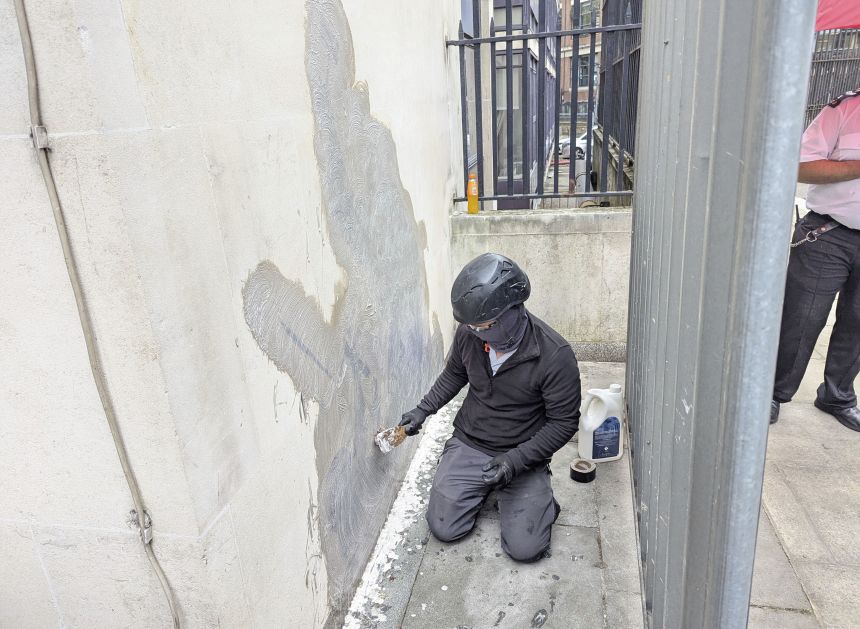 A worker removing the artwork from the Royal Courts of Justice in London on Wednesday, September 10, 2025.