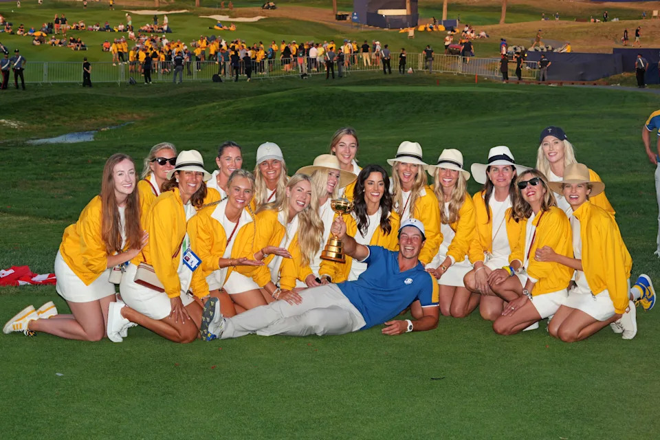Team Europe golfer Viktor Hovland poses with the Ryder Cup and the partners of the other players after Team Europe beat Team USA during the final day of the 44th Ryder Cup golf competition at Marco Simone Golf and Country Club.