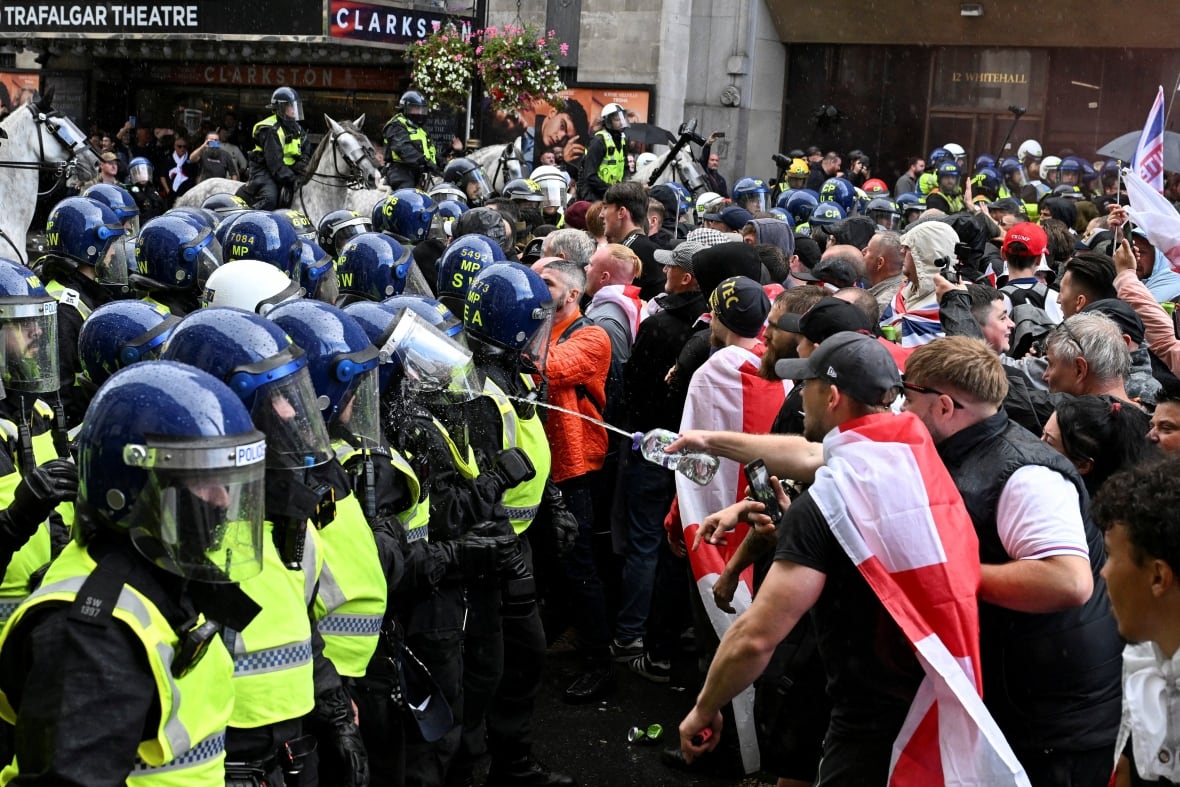 Police face off with protesters in a street.