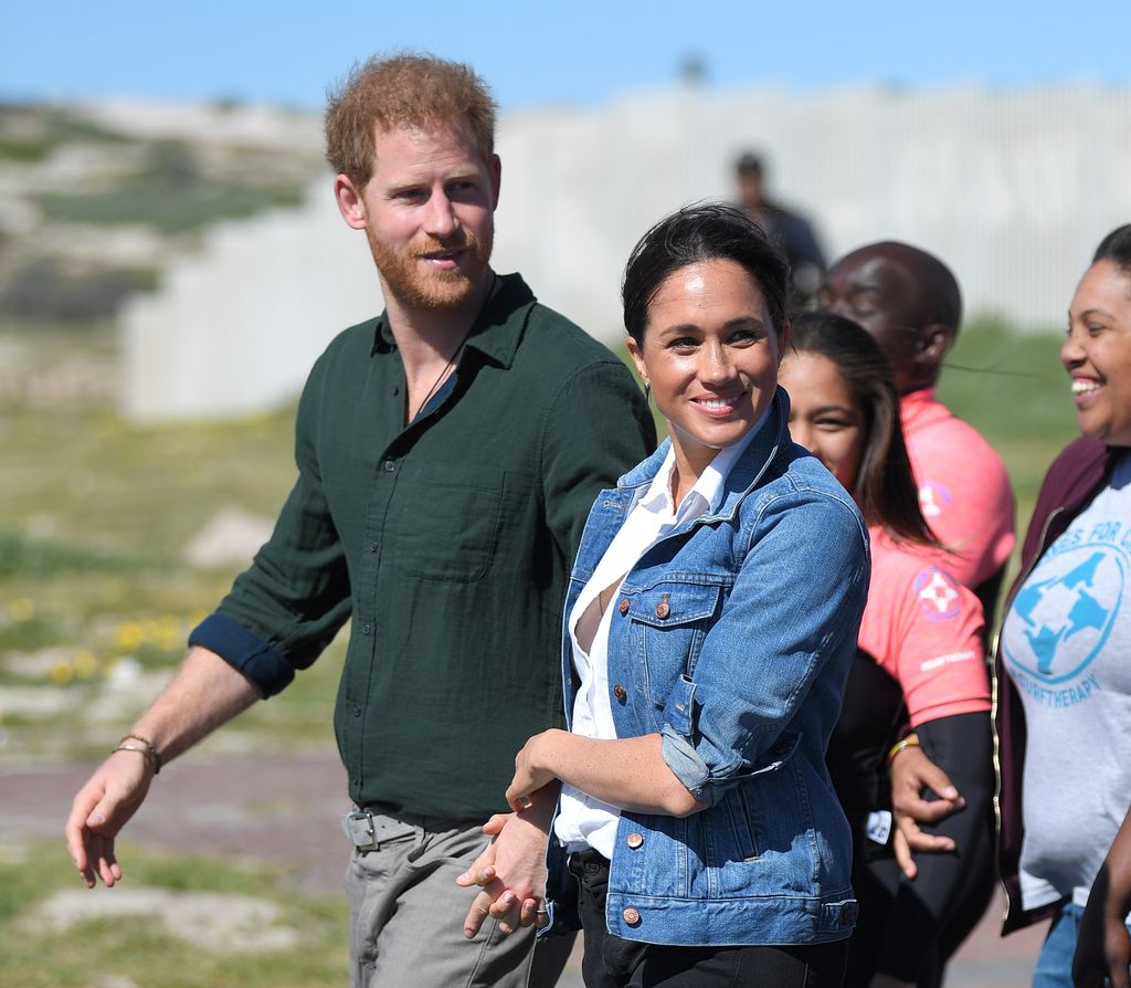 Prince Harry and Meghan Markle walking by some cliffs