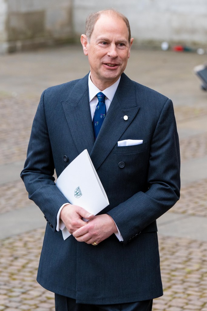 Prince Edward wears a navy suit and blue tie