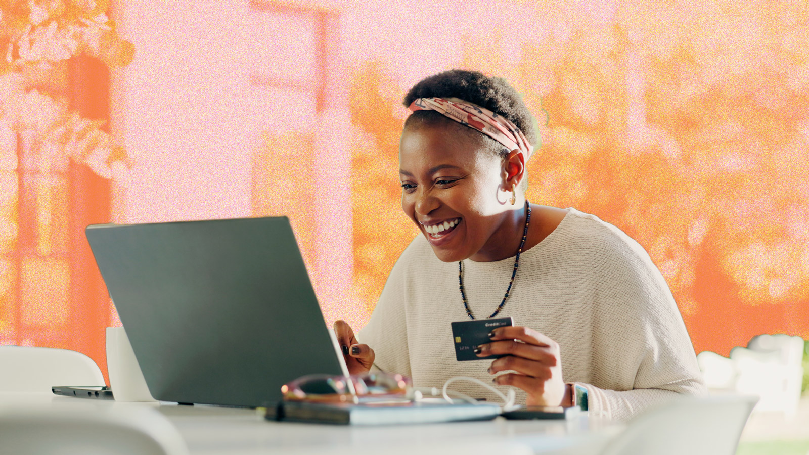 A woman looking happy whilst online shopping on a laptop.