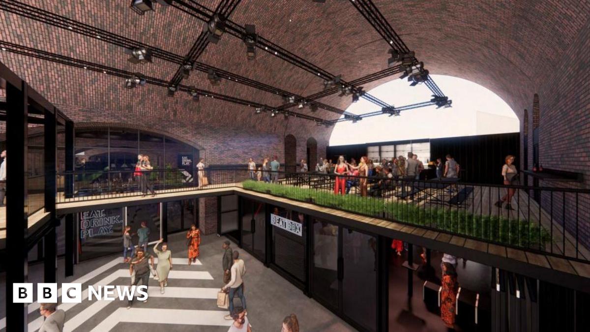 A CGI of a food and retail space under railway arches, with people walking around and sitting in a open two-level space with iron railings on the second floor.