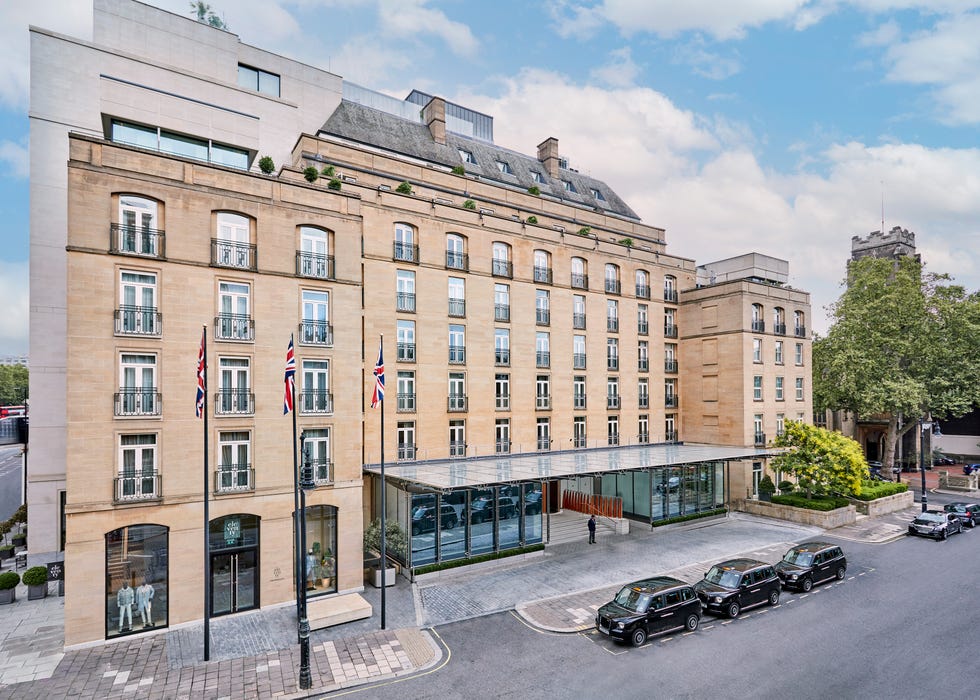 Luxury hotel exterior with main entrance and parked taxis