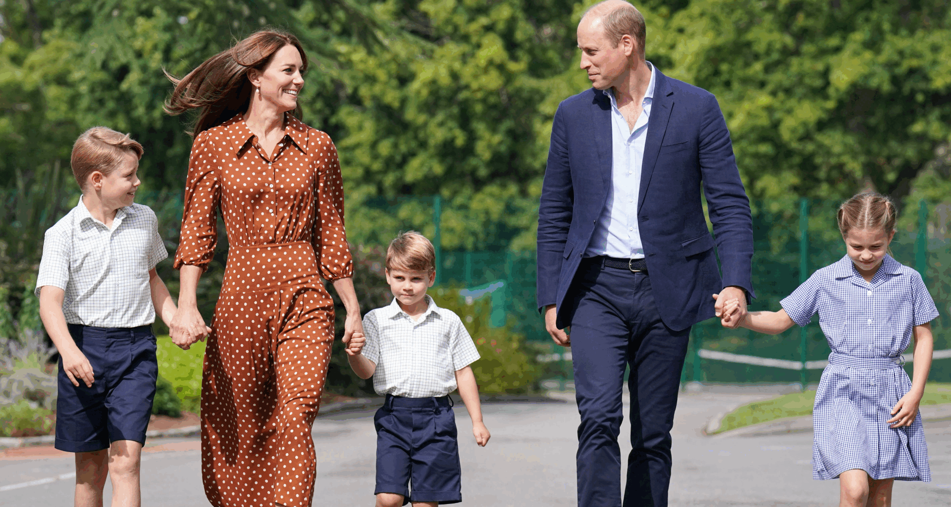 Prince George, Kate Middleton, Prince Louis and Princess Charlotte holding hands in a line with their parents walking to school