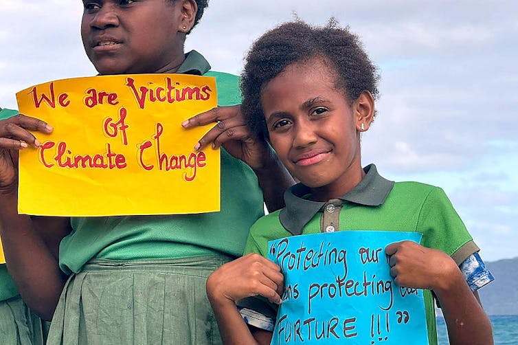 school children from vanuatu holding signs about climate change.