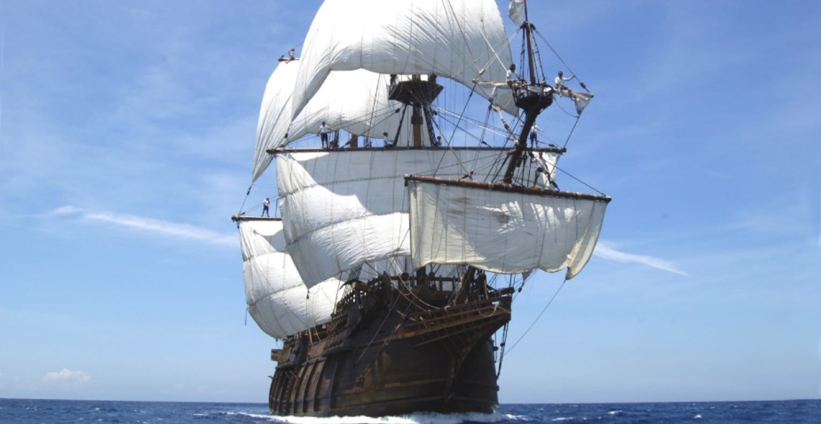 A full-size replica of a seventeenth-century Spanish galleon sailing on the sea on a sunny day