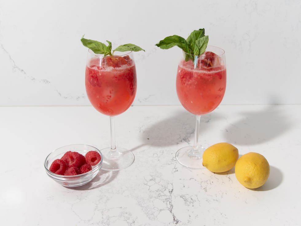 meghan markle sparkling raspberry lemonade meghan markle sparkling raspberry lemonade in 2 wine glasses with a bowl of raspberries and a halved lemon