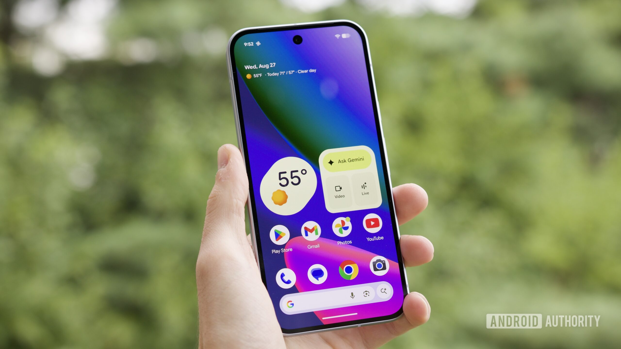 Someone holding the Google Pixel 10 with its screen on, showing the home screen.