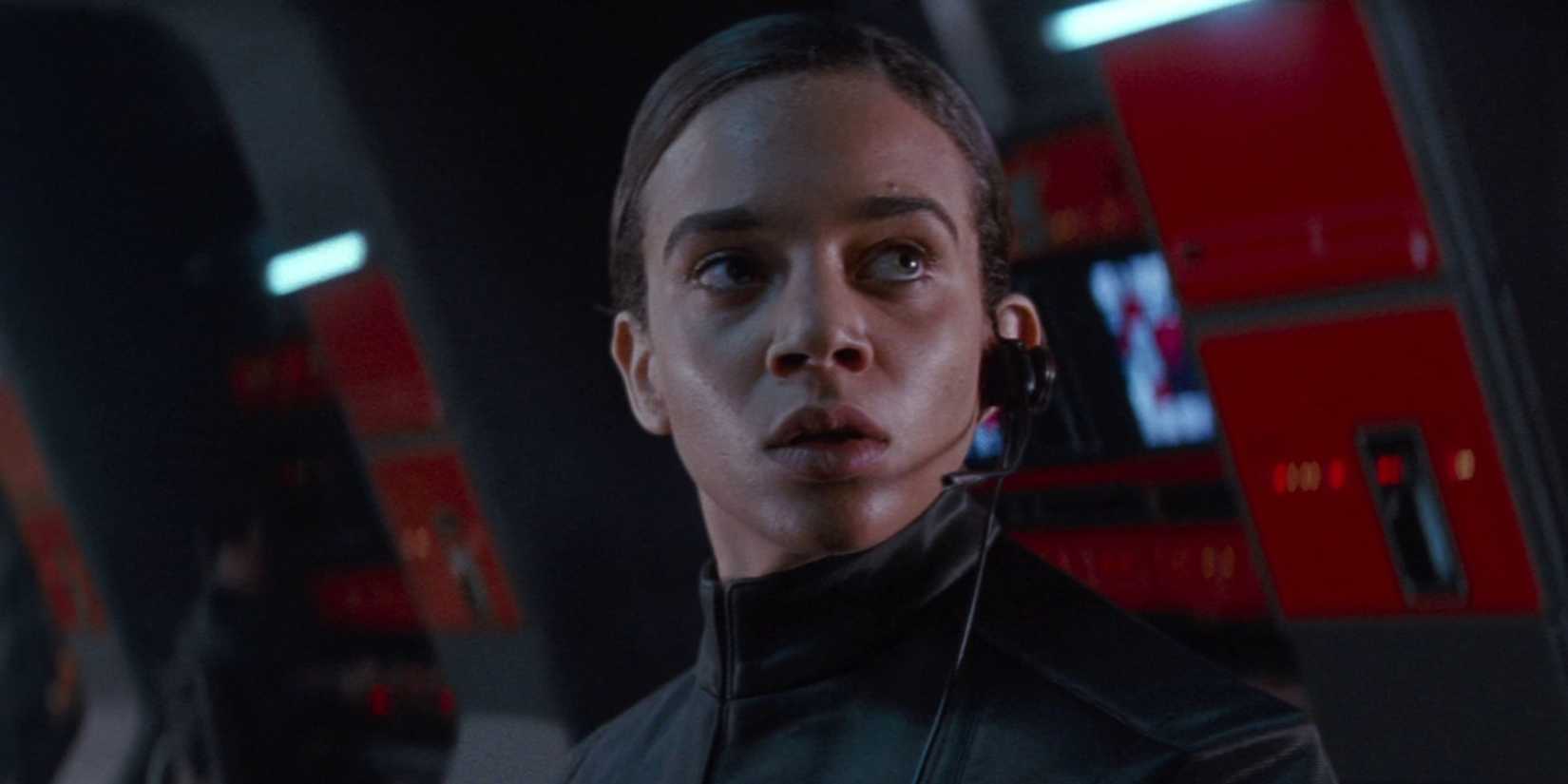 Hannah John-Kamen sitting at a desk in Starkiller Base in Star Wars: The Force Awakens (2015)