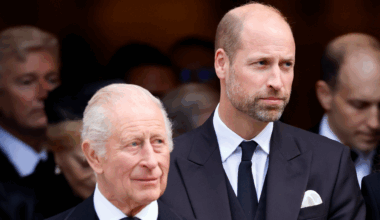 Prince William and King Charles wearing suits and ties standing next to each other