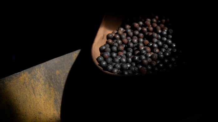 A container partially filled with small, round graphite pellets sits in shadow at the Northern Graphite mine plant.