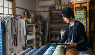 Mature woman inspecting the finished textile fabric she designed after manufacturing