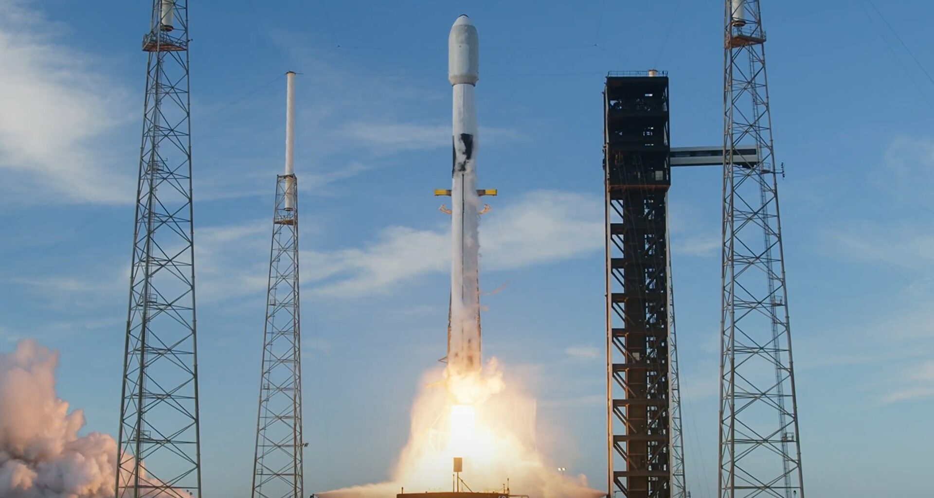 a white rocket lifts off above a plume of fire and smoke