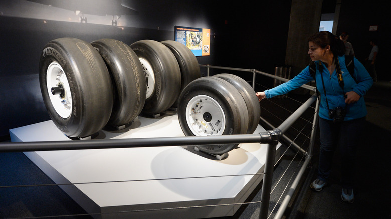 A woman touches the tires of space shuttle Endeavour after the grand opening ceremony of the exhibit at the new Samuel Oschin Pavilion of the California Science Center on October 30, 2012 in Los Angeles, California. The Orbiter arrived in Los Angeles in late September atop a modified Boeing 747.