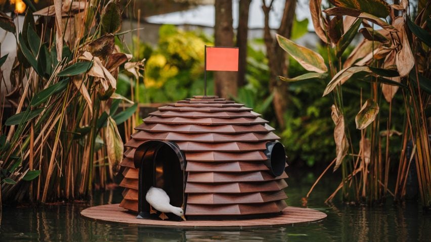 Duck peeping out of pinecone-shaped hut