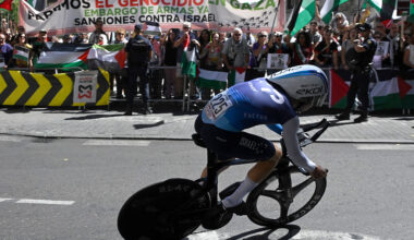 Pro-Palestinians protesters wave Palestinian flags as Team Israel Premier Tech's Israeli rider Nadav Raisberg competes during the 18th stage of the Vuelta a Espana, a 26 km race against the clock between Valladolid and Valladolid, on September 11, 2025. (Photo by Miguel RIOPA / AFP)