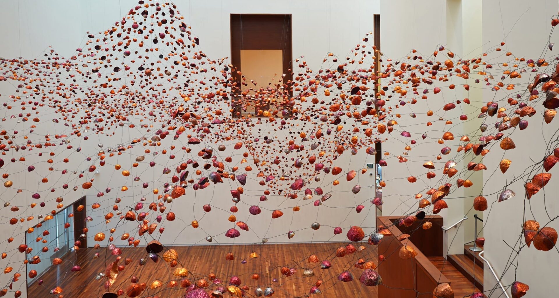 an installation view of a room-size installation by Yasuaki Onishi made of hundreds of copper forms connected by wire