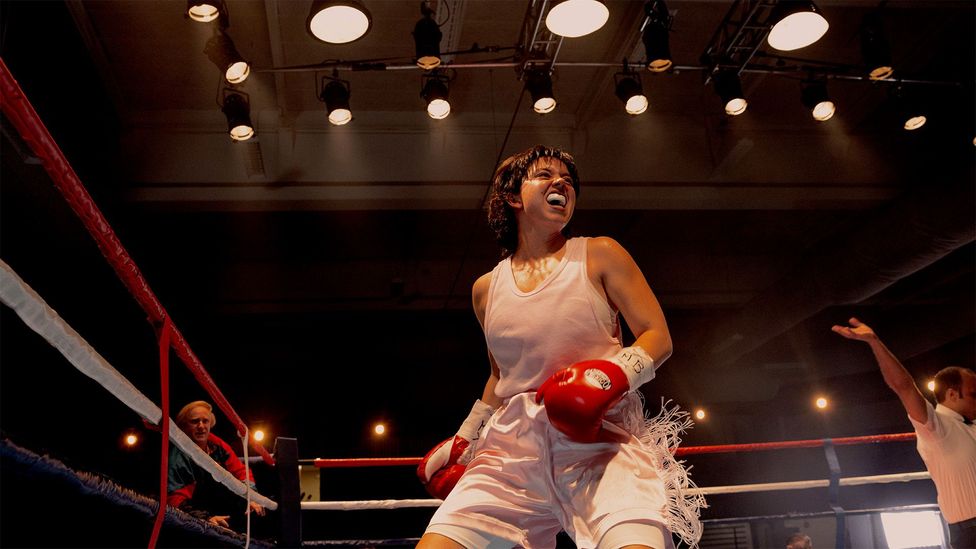 Sydney Sweeney as Christy Martin, in a boxing ring, wearing a white top and shorts, red boxing gloves and a white gum shield (Credit: Courtesy of TIFF)