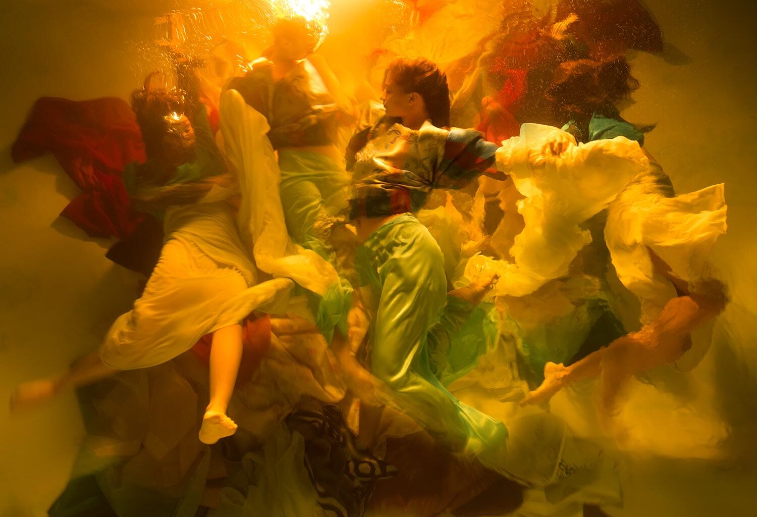 an underwater photograph by Christy Lee Rogers of figures enveloped in billowing fabric