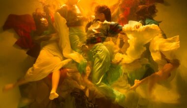 an underwater photograph by Christy Lee Rogers of figures enveloped in billowing fabric