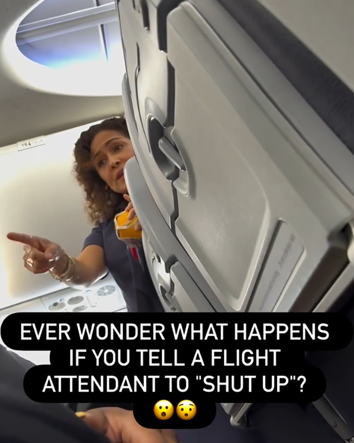 Flight attendant pointing inside airplane cabin at an entitled passenger kicked off flight for telling attendant to shut up.