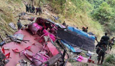 Rescue workers stand by the crash debris. Pic: AP