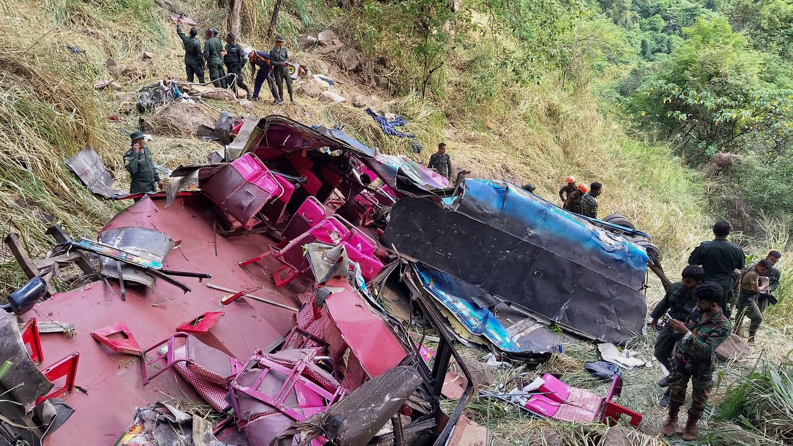 Rescue workers stand by the crash debris. Pic: AP