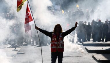 A protester holds a CGT labour union flag amid tear gas during clashes with police in Nantes. Pic: Reuters