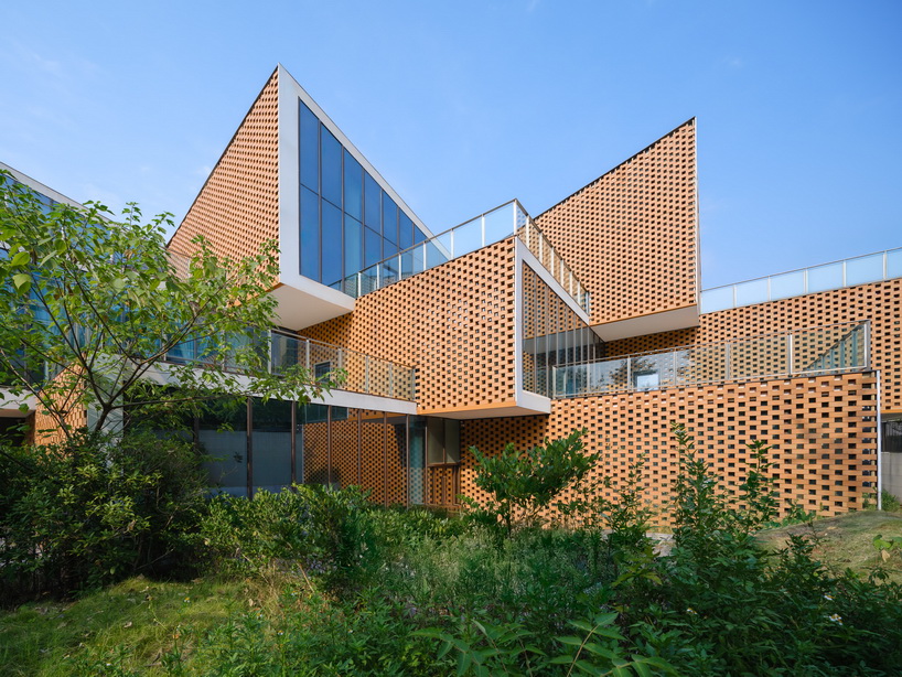 permeable terracotta brick screens wrap kindergarten's stacked volumes by NAN architects