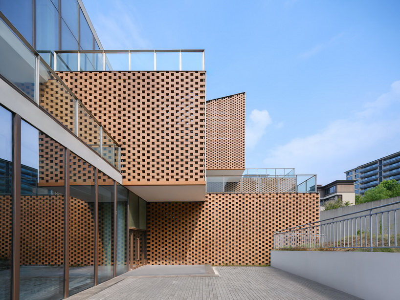 permeable terracotta brick screens wrap kindergarten's stacked volumes by NAN architects