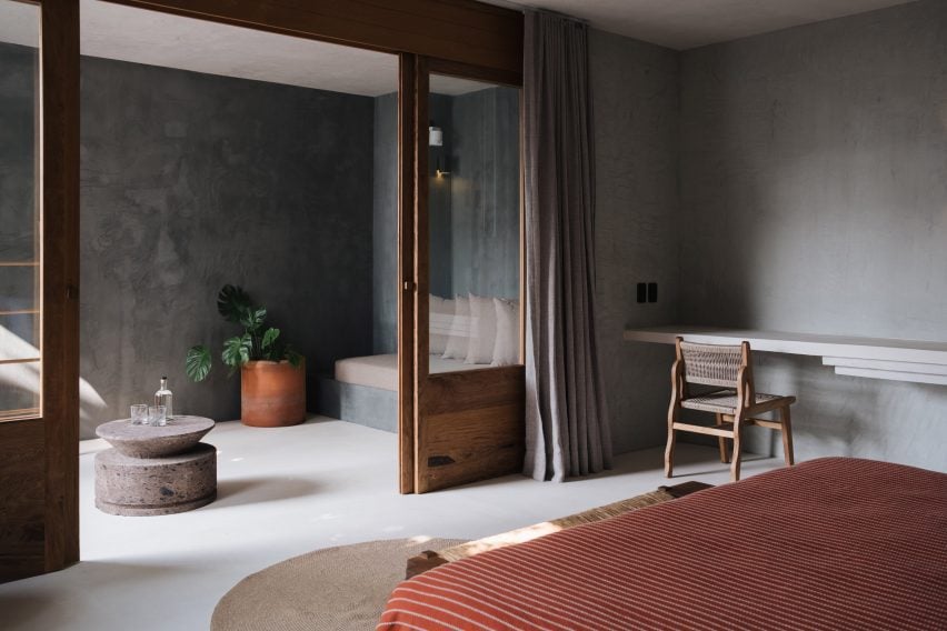 Covered balcony featuring built-in seating, stone tables and terracotta plant pots