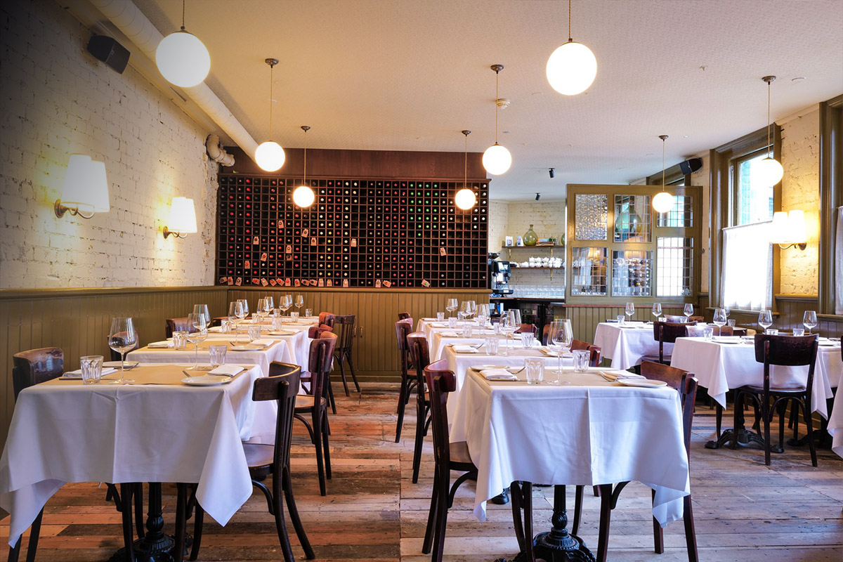 interiors of the devonshire pub with tables set and round lights hanging from the ceiling