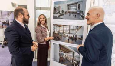 Three people looking at a set of visualisations and floor plans.