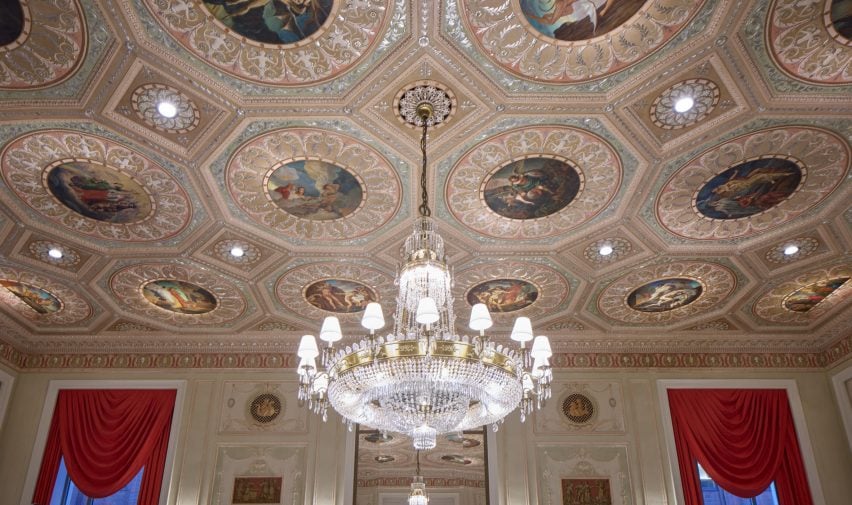 Grand room with an ornate ceiling and large chandelier