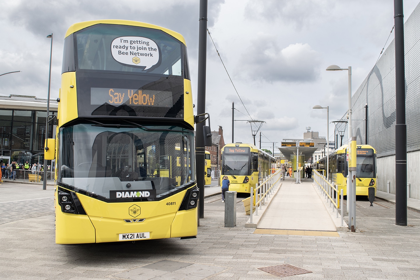 yellow-bus-next-to-trams-part-of-bee-network half price travel manchester