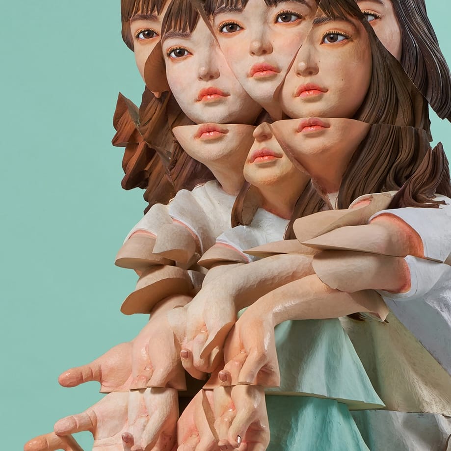 a wooden sculpture by Yoshitoshi Kanemaki of a seated female figure with prismatic or fragmented features