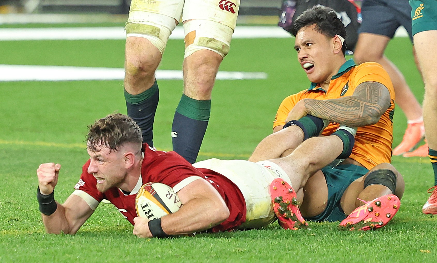 Tom Curry celebrating a try against Bundee Aki during a rugby match.