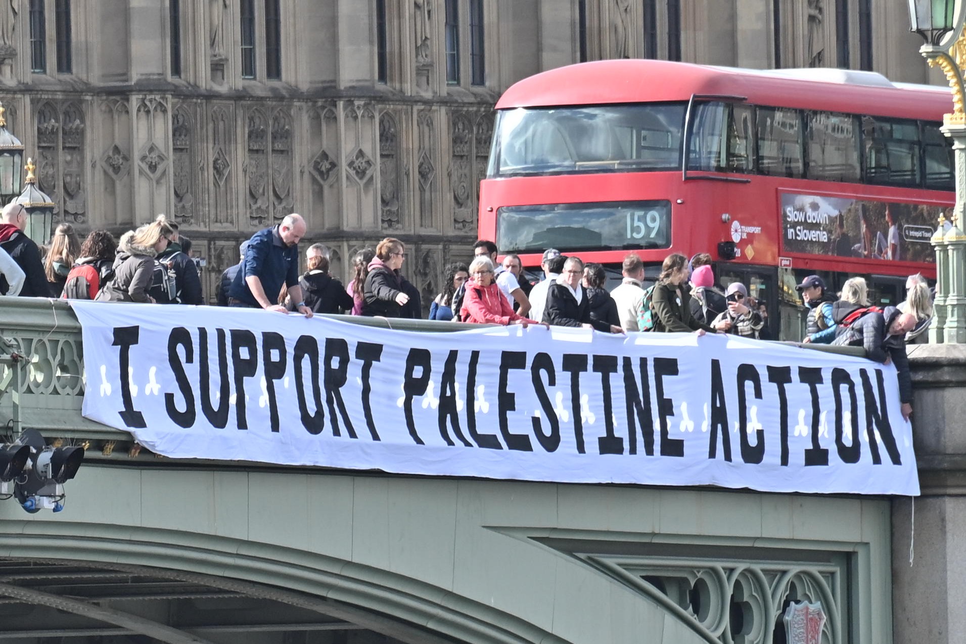 Activists dropping a banner from Westminster Bridge that reads “I Support Palestine Action.”